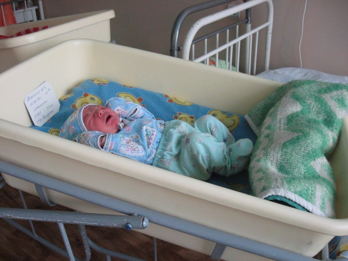 Новорожденные в кроватке в роддоме